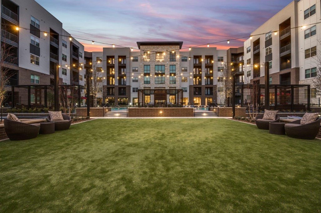 A large grassy area in front of apartment buildings.