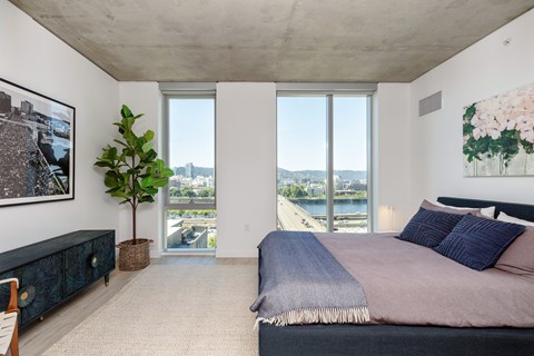 A bedroom with a large bed and a view of the city.
