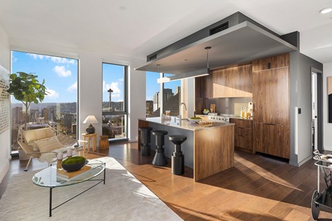A modern kitchen with a glass table and bar stools.