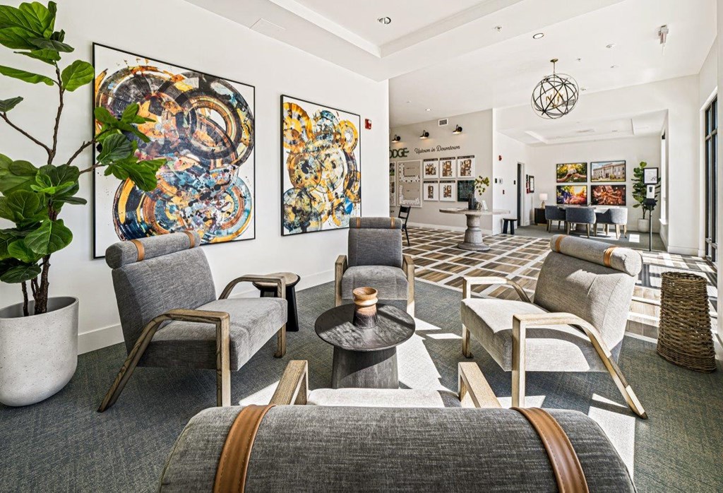 the lobby of a hotel with chairs and paintings