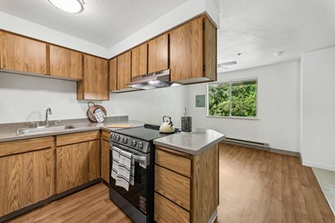 A kitchen with wooden cabinets and a black stove top oven.