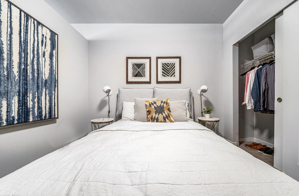 a bedroom with a white bed and a closet