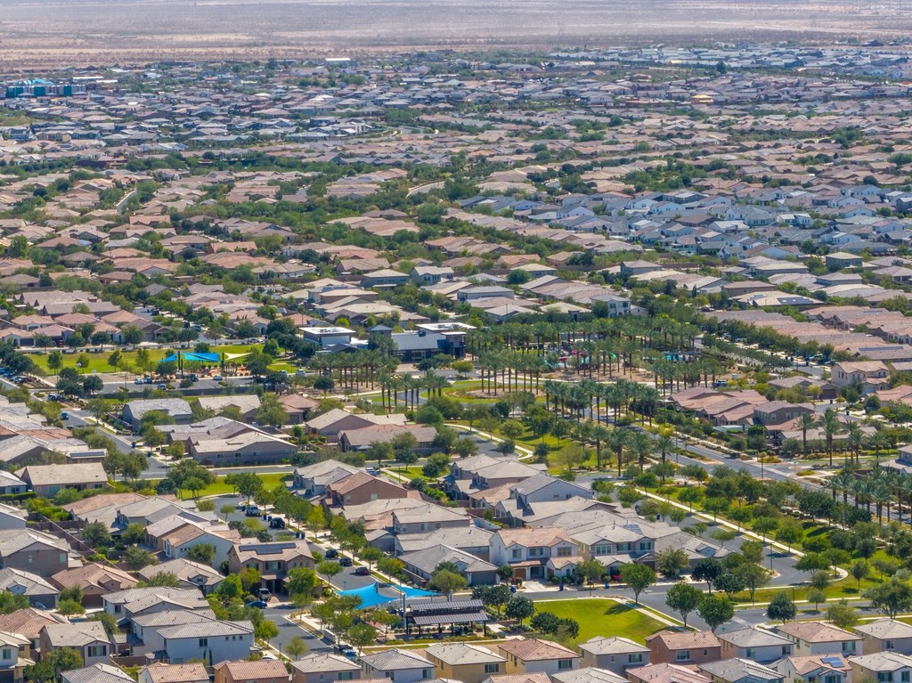 A bird's eye view of a residential neighborhood with houses and swimming pools.