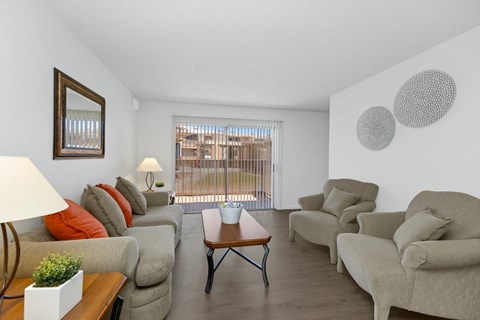 A living room with a couch, chairs, and a table.