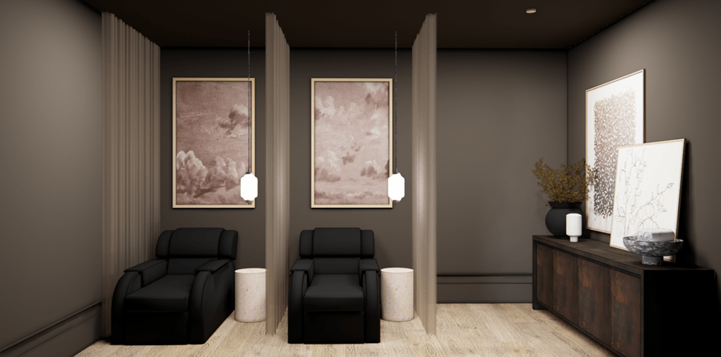 Two black chairs are in front of two framed pictures.