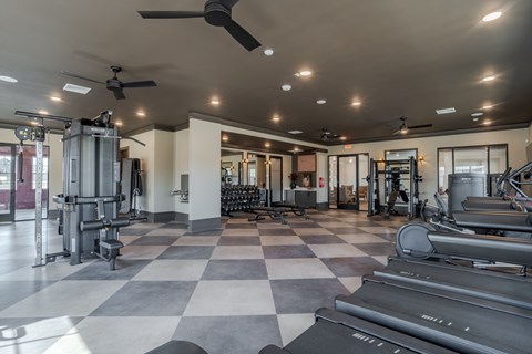 A spacious gym with a variety of equipment and a checkered floor.