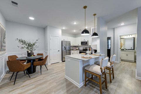 A modern kitchen with a dining table and chairs.