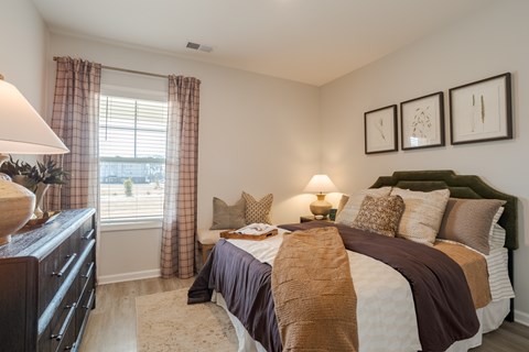 A bedroom with a large bed and a dresser.