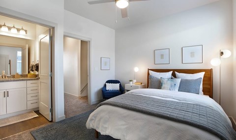 A bedroom with a large bed and a vanity with a mirror.