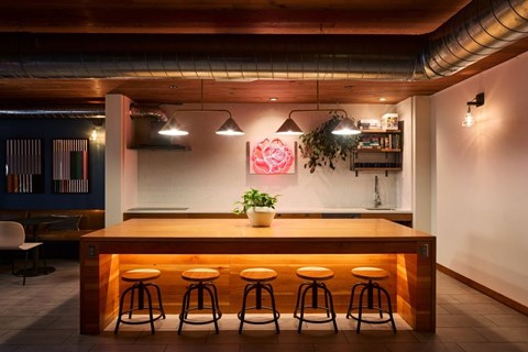 A bar with a wooden counter and four stools.