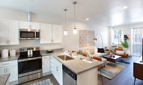 A modern kitchen with white cabinets and stainless steel appliances.
