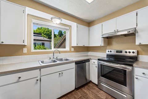 A kitchen with white cabinets and stainless steel appliances.