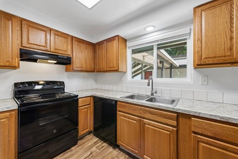 A kitchen with wooden cabinets and a black stove top oven.