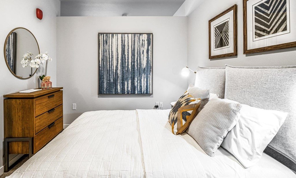 a bedroom with a white bed and a dresser