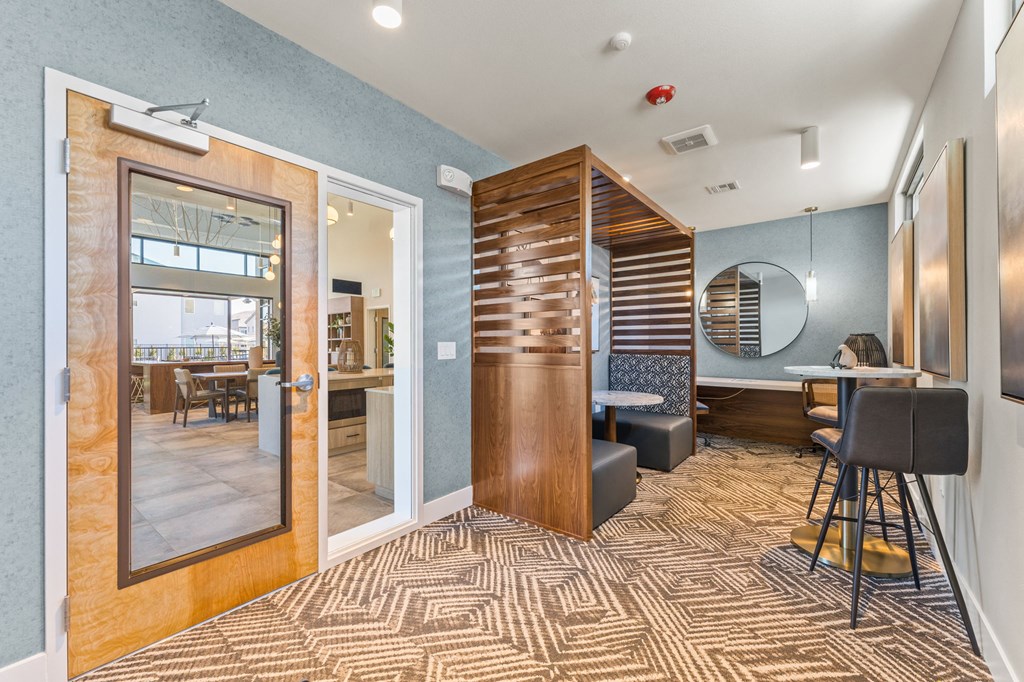 a lobby with a bar and a dining room with a table and chairs
