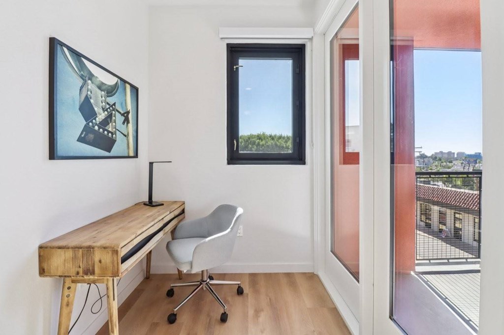 A room with a desk and chair with a window.
