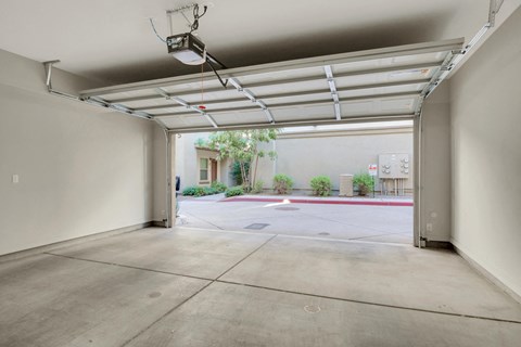 A large, empty garage with a view of a parking lot and a building outside.