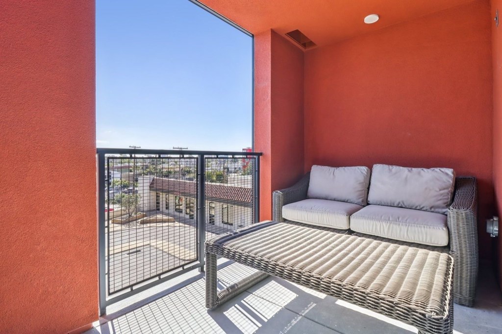 A patio with a couch and a table with a metal railing.