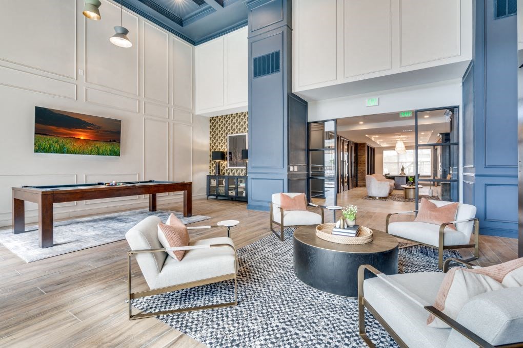 a resident clubhouse with couches chairs and a pool table