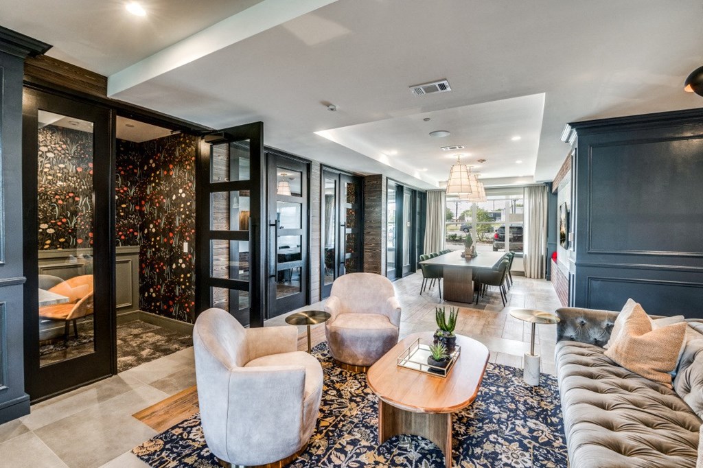a living room with couches and chairs and a dining room in the background