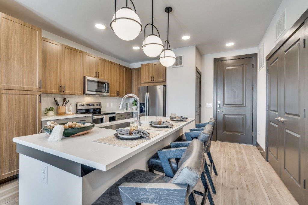 a kitchen with a long island with a bunch of chairs