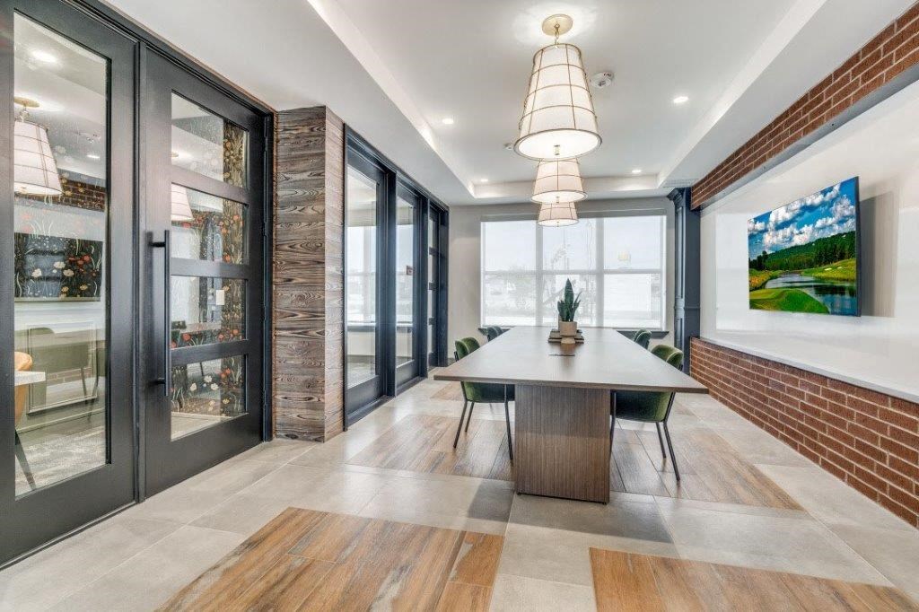 a dining room with a table and chairs in front of a brick wall