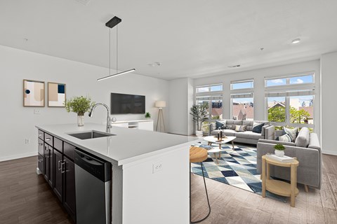 A modern kitchen with a large island and a living room with a couch and a coffee table.