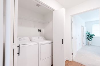 A white laundry room with a washer and dryer.