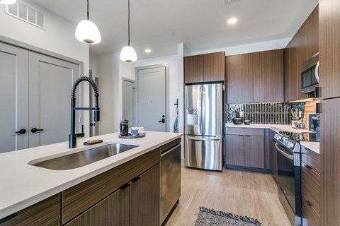 a kitchen with wooden cabinets and a stainless steel refrigerator