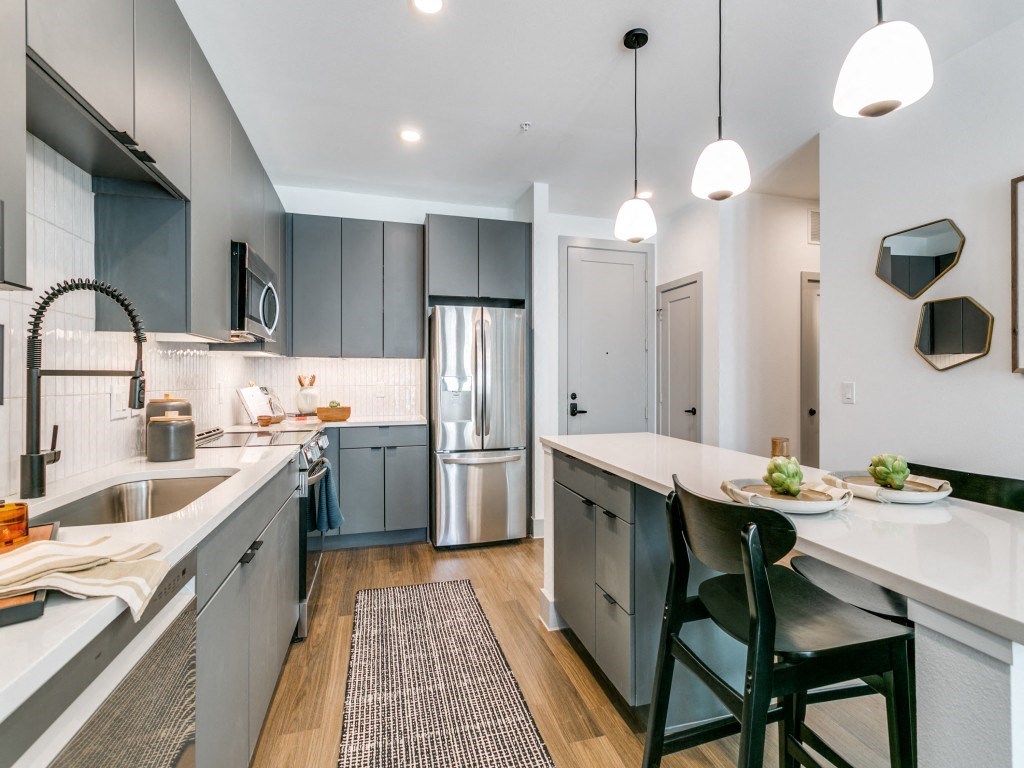 an open kitchen and dining area with a large island and stainless steel appliances