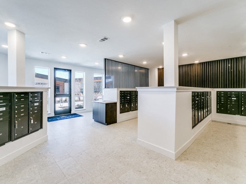 the inside of a building with a reception desk and mailboxes