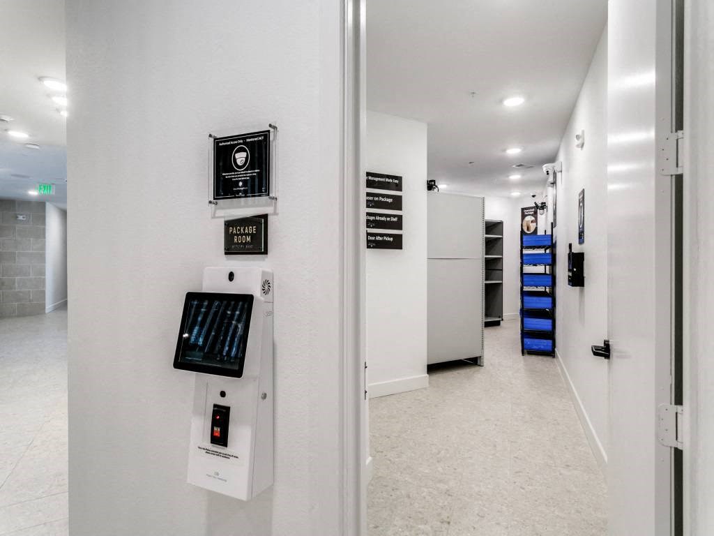 the hallway of a building with a white wall and electronics on it