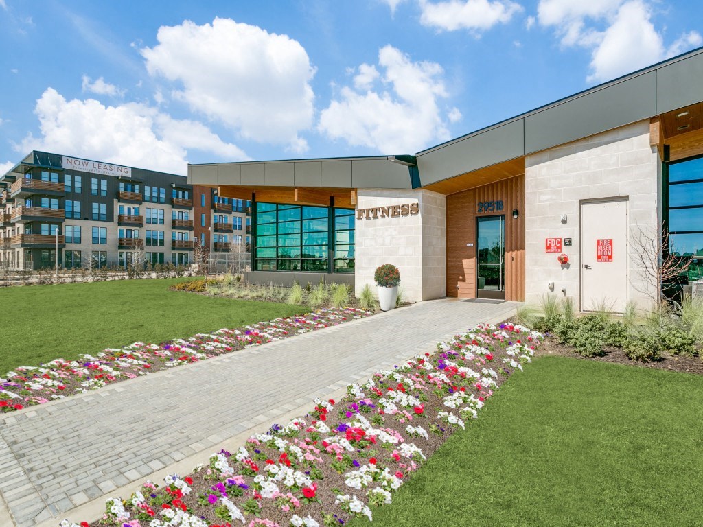 a building with a lawn and flowers in front of it