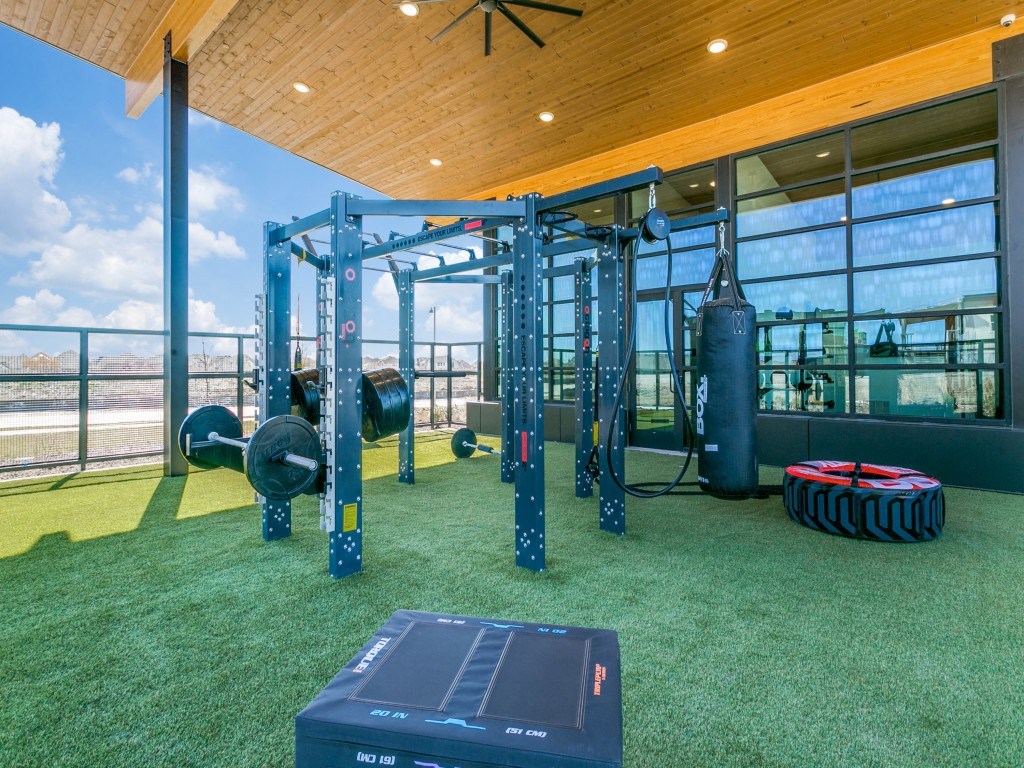 a gym with weights and other equipment on the grass