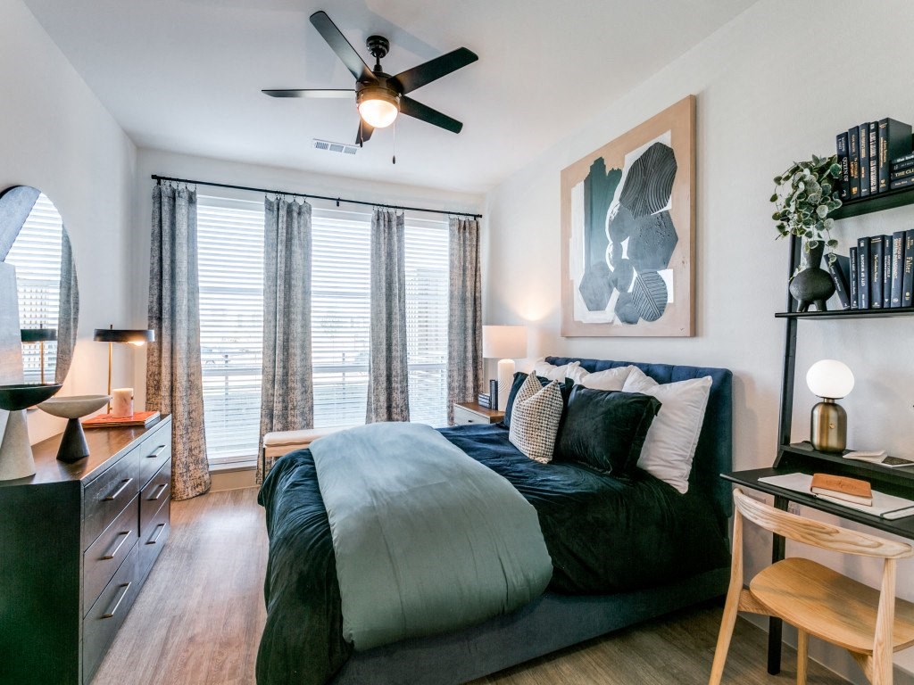 a bedroom with a large bed and a ceiling fan