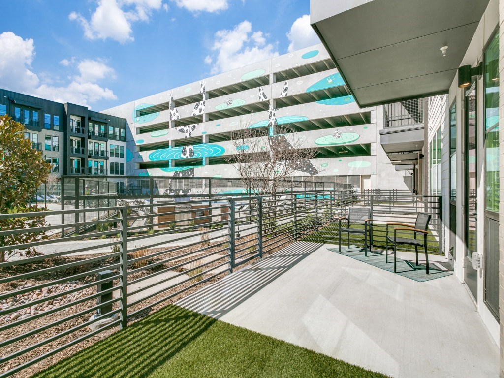 a balcony with a view of a building and a train track
