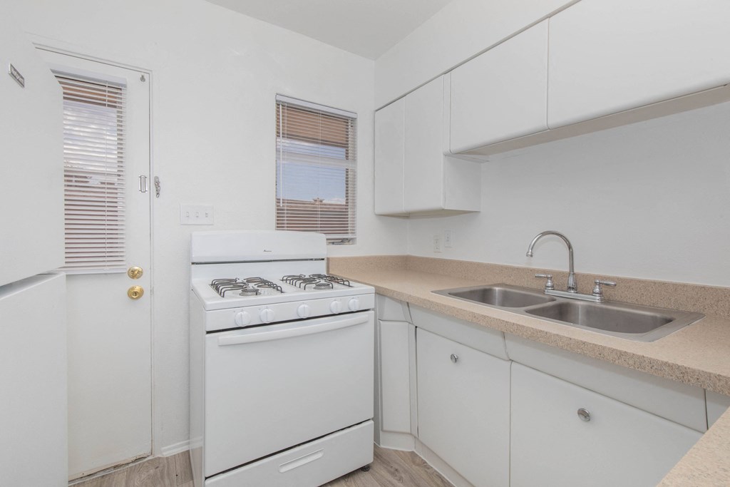 A white kitchen with a sink and a stove.