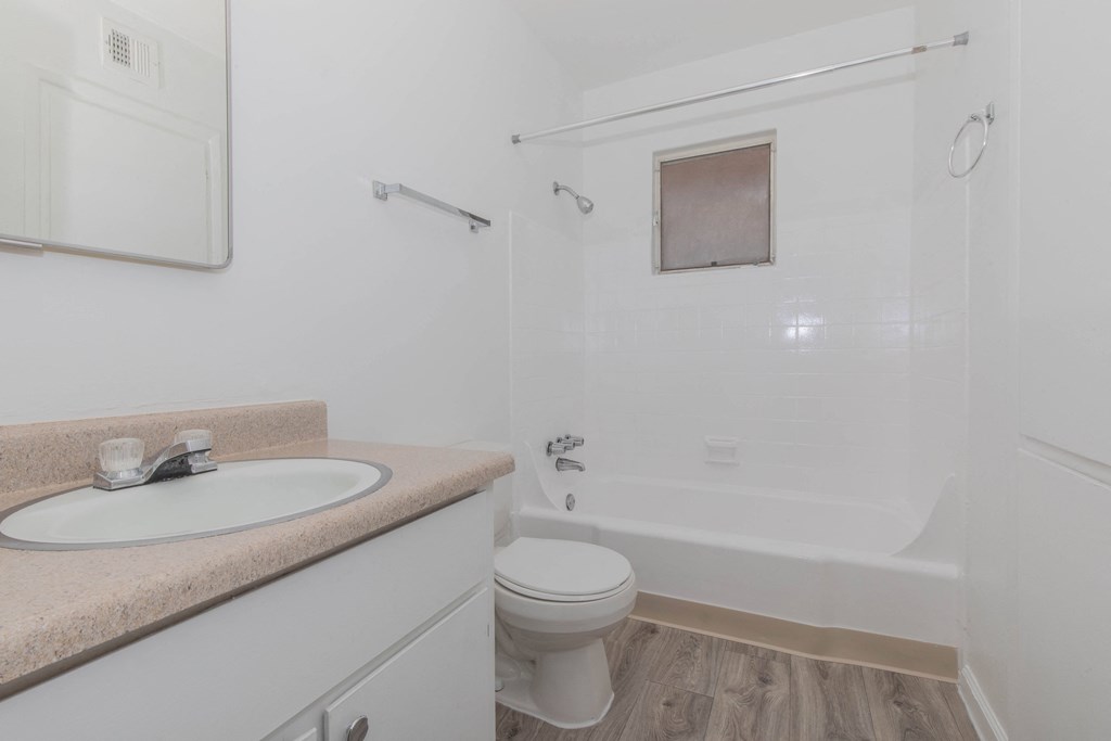 A white bathroom with a sink, toilet, and bathtub.