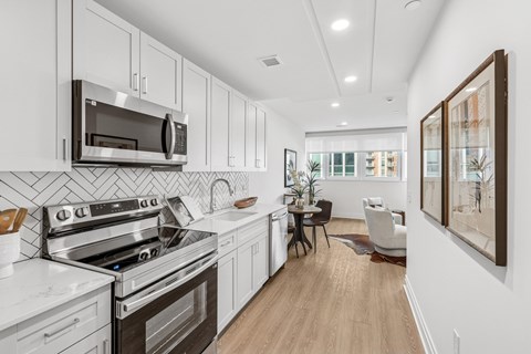 A modern kitchen with white cabinets and stainless steel appliances.