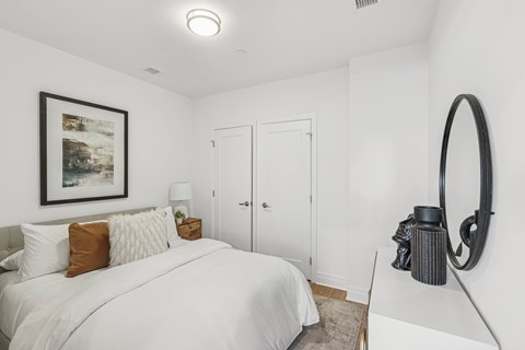 A bedroom with a large bed and a framed picture on the wall.