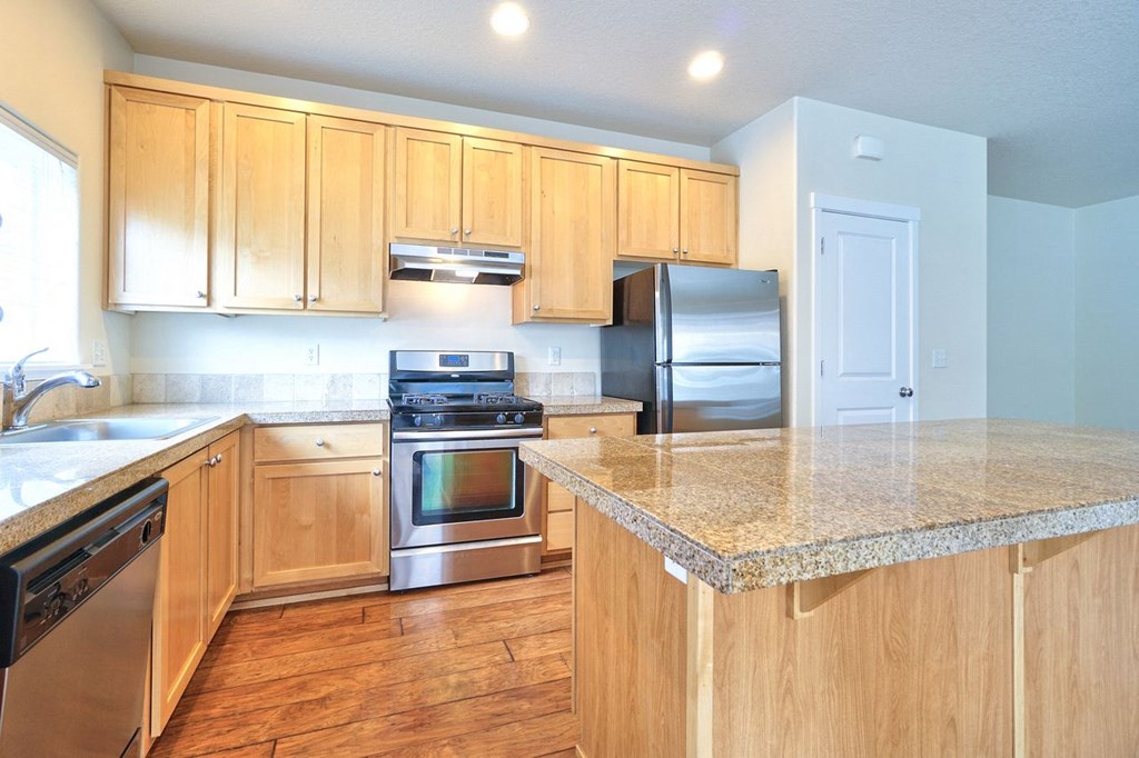 a kitchen with wooden cabinets and stainless steel appliances