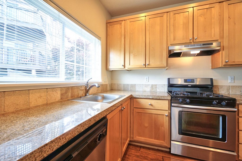 a kitchen with wooden cabinets and stainless steel appliances