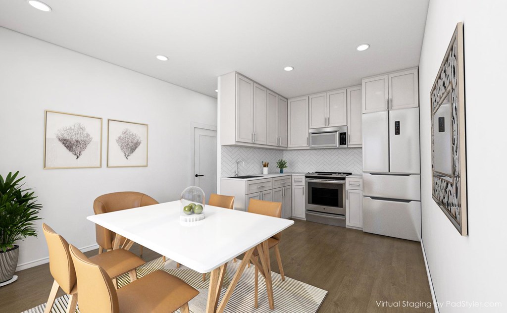 A dining room with a white table and chairs.