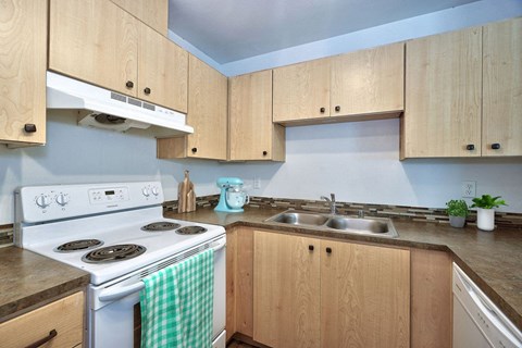 a kitchen with white appliances and wooden cabinets
