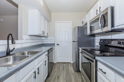 A kitchen with white cabinets and stainless steel appliances.