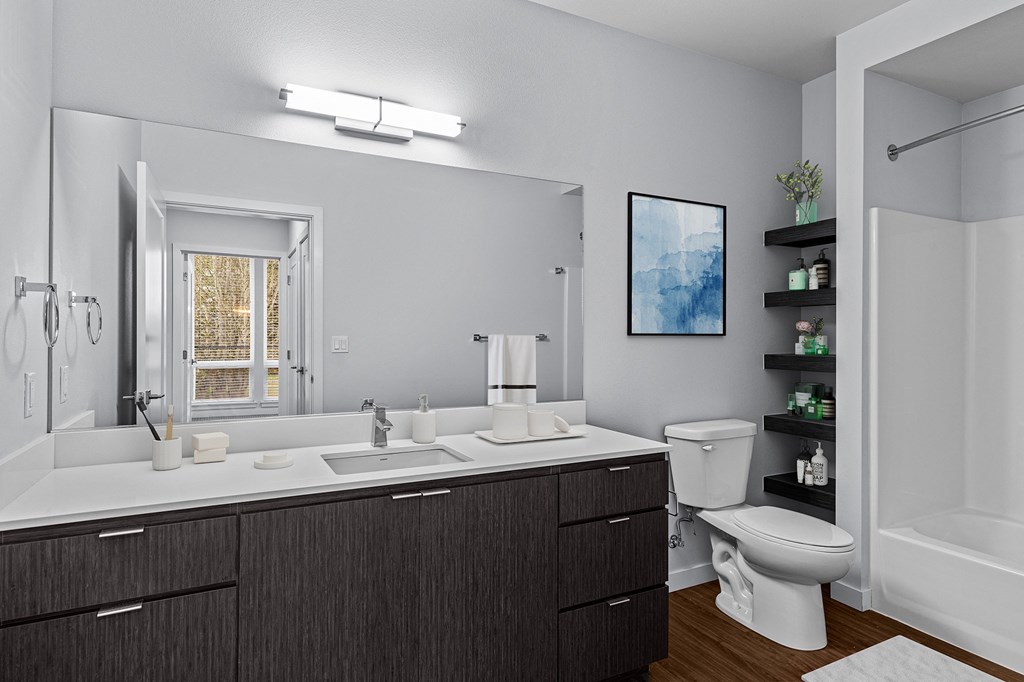 a bathroom with a large mirror and a toilet and sink