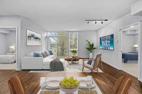 A dining room with a table set for two and a view of the backyard.