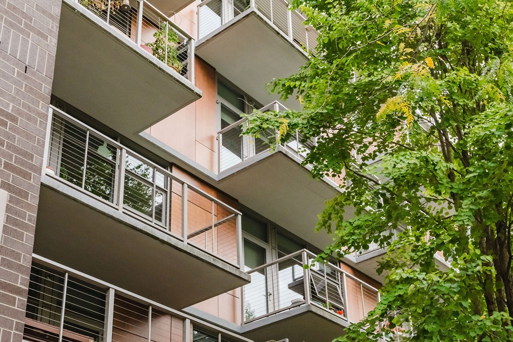 A building with balconies and windows surrounded by trees.