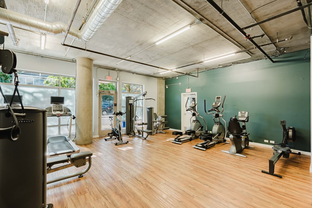 A gym with a variety of equipment including treadmills, stationary bikes, and weight machines.