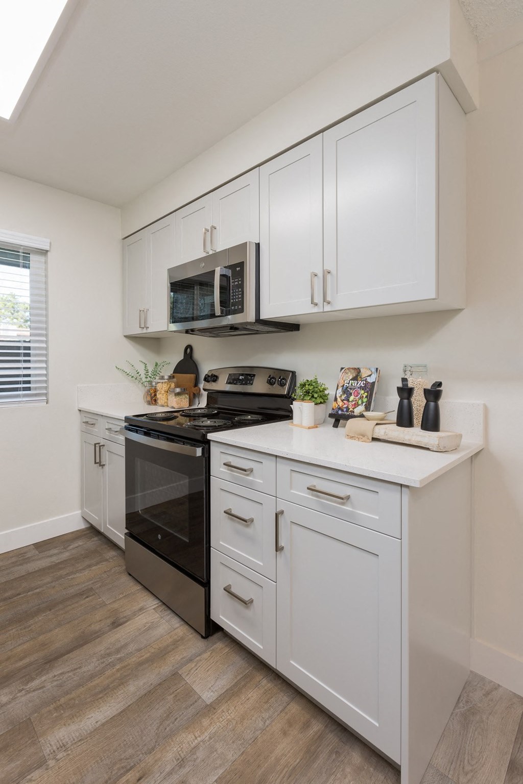 a kitchen with white cabinets and a stove and a microwave